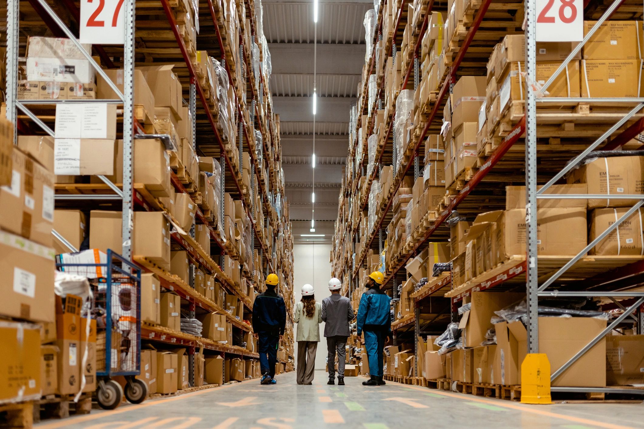 Equipo recorriendo un almacén de inventario, simbolizando coordinación y control logístico