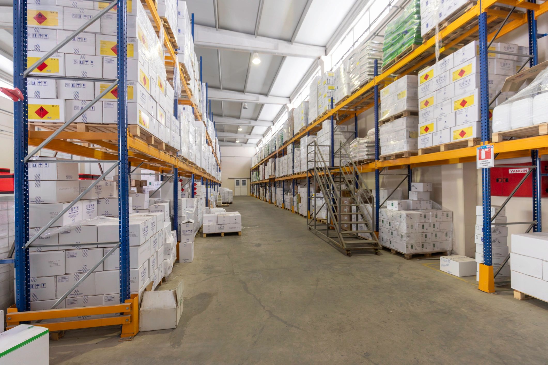 Pasillo de almacén con estanterías y cajas, entorno logístico organizado